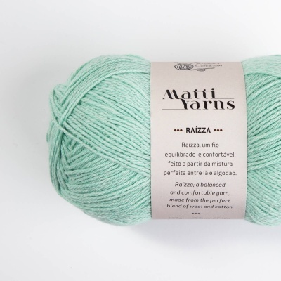 Skein de fio verde água com rótulo branco e texto em português e inglês