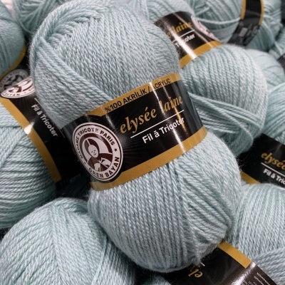 Bolas de lã acrílica cinza claro com rótulos pretos e dourados agrupadas