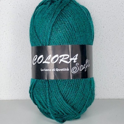 Novelo de lã verde-azul com etiqueta preta sobre fundo branco texturizado