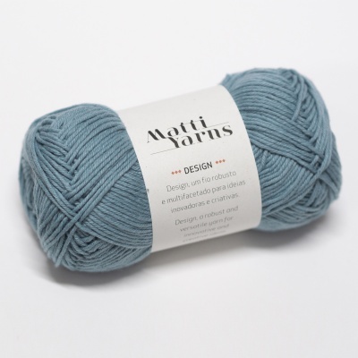 Novelo de lã azul acinzentada com etiqueta branca da marca Motti Yarns