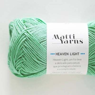 Novelo de fio verde claro com etiqueta branca Matti Yarns Heaven Light