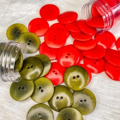 Botões verdes e vermelhos em tecido branco