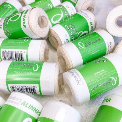 Rolos de linha de algodão com etiquetas verdes e brancas