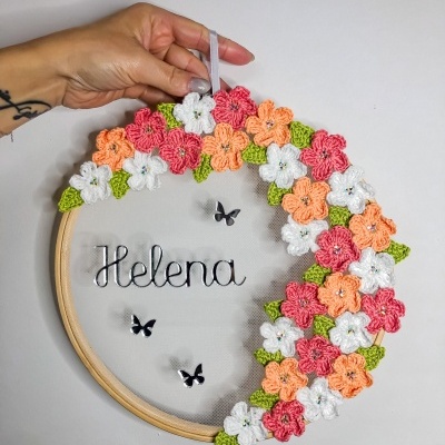 Guirlanda com flores de crochê coloridas e nome Helena em tule com base de madeira