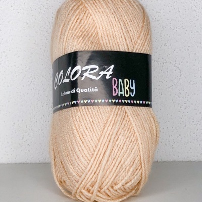 Novelo de lã bege claro com etiqueta preta escrita Colorá Baby.
