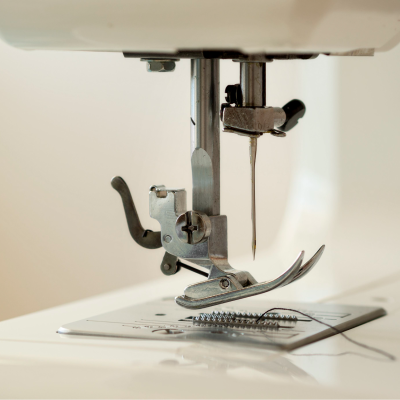 Close-up de agulha e calcador de máquina de costura branca