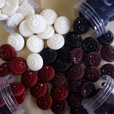 botões redondos decorativos em branco, preto e vermelho em frascos transparentes