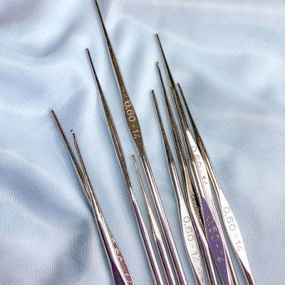 Agulhas metálicas finas para costura ou crochet sobre tecido azul claro