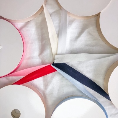 Vários rolos de fita de tecido coloridos sobre pano branco