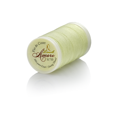 Bobina de linha verde claro com etiqueta Amore no fundo branco