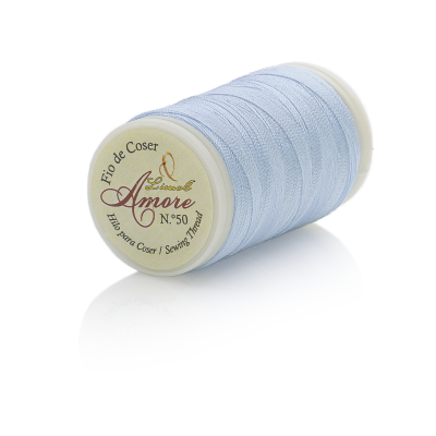 Carretel de linha azul claro para coser com etiqueta redonda em fundo branco