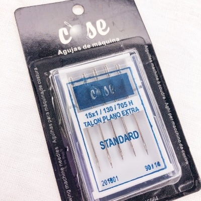 embalagem de agulhas para máquina de costura com cinco agulhas e texto em português e espanhol