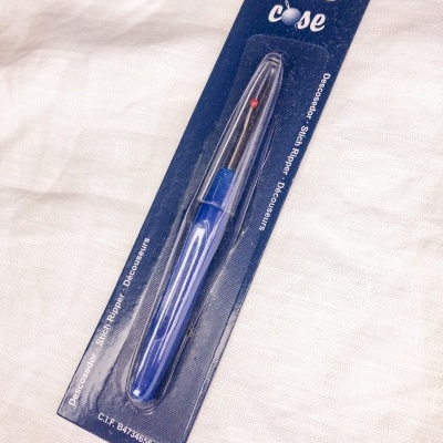 Removedor de etiquetas em embalagem azul sobre tecido claro