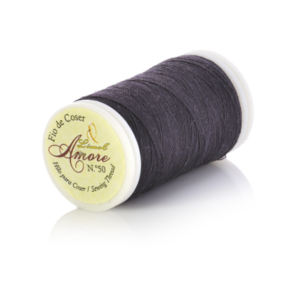 Bobina de linha preta com rótulo amarelo sobre superfície branca