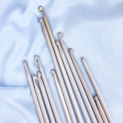 Agulhas de tricô de alumínio prateadas sobre tecido azul claro