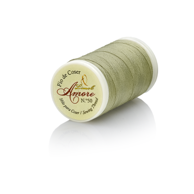 Rolo de linha de coser verde com etiqueta Amore no fundo branco