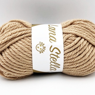 Novelo de lã bege com etiqueta branca e dourada em fundo branco