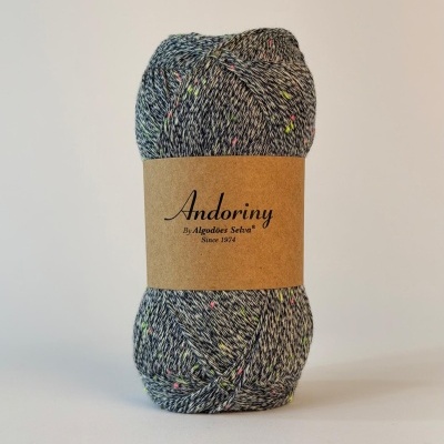 Novelo de fio cinzento com manchas coloridas e embalagem com texto