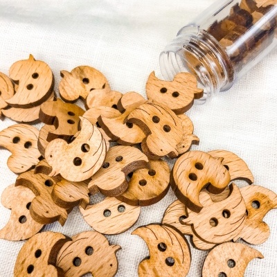 Botões de madeira em forma de coruja em tecido branco
