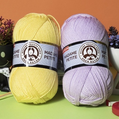 Dois novelos de lã Madame Petite amarelo claro e lilás com etiquetas brancas e pretas