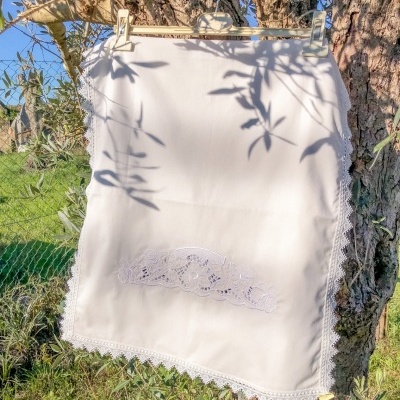 Saia branca com renda pendurada numa árvore ao ar livre