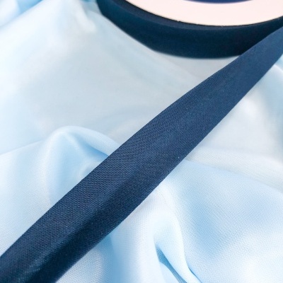 Fita azul escura em rolo com etiqueta sobre tecido azul claro