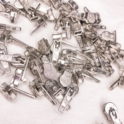 Fechos metálicos prateados para roupas sobre tecido branco