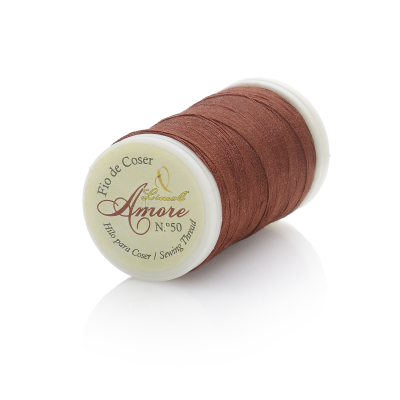 Carretel de linha de coser castanho com etiqueta e fundo branco