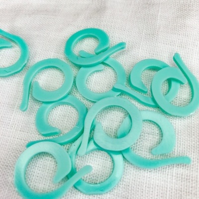 Clips de plástico turquesa em forma circular sobre tecido branco