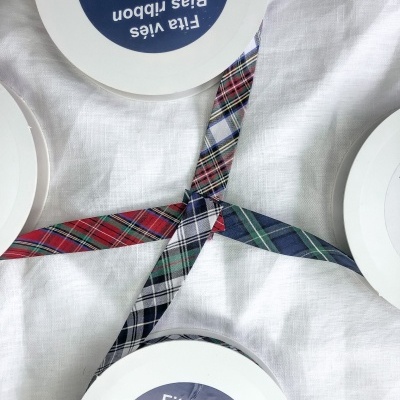 rolos de fita viés xadrez colorida sobre pano branco