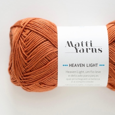Skein of orange yarn with Matti Yarns label on white background