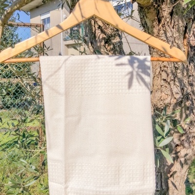 Toalha branca texturizada pendurada em cabide de madeira ao ar livre