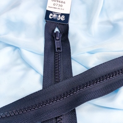 Fecho éclair preto sobre tecido azul claro com etiqueta visível