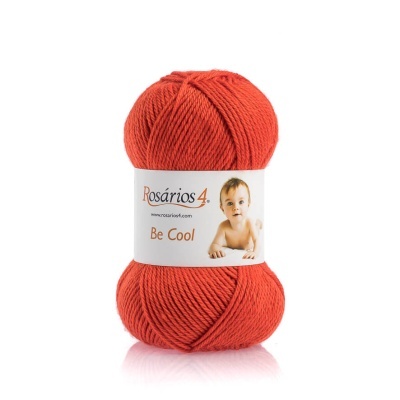 Novelo de lã cor de laranja com etiqueta branca e imagem de um bebé