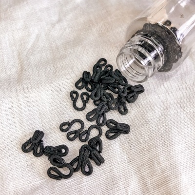 Frasco com ganchos pretos em tecido creme