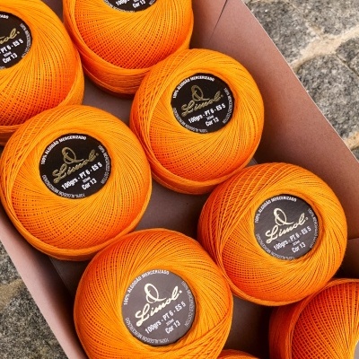 Novelos de linha de algodão laranja em caixa de cartão