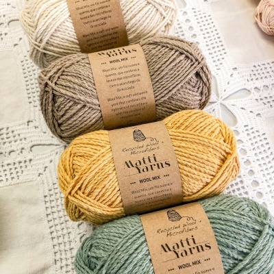 Skeins de lã Matti Yarns Wool Mix em várias cores sobre toalha rendada branca