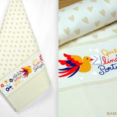 Toalha decorativa com corações bege e faixa com texto colorido e ilustração de pássaro