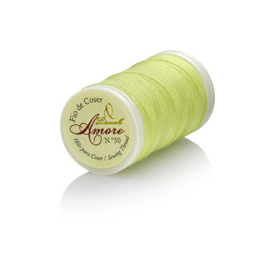 Carretel de linha de costura Amore amarelo claro sobre superfície branca