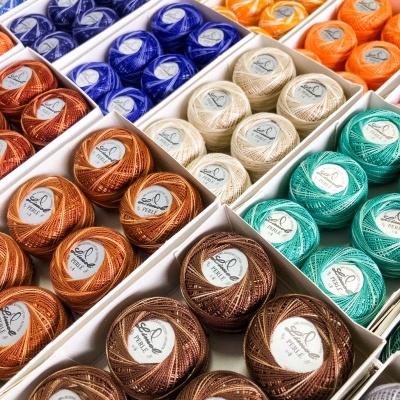 Linhas de bordado de várias cores organizadas em caixas