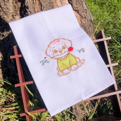Toalha branca bordada com cão e texto 'For You' sobre estrutura de madeira ao ar livre