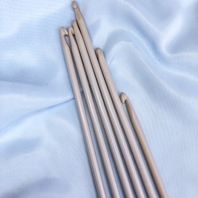 agulhas de tricô douradas sobre tecido azul claro