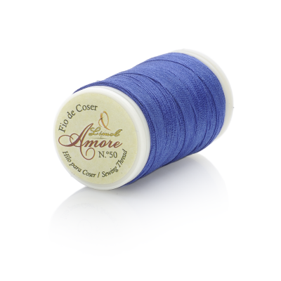 Rolo de fio de coser azul roxo com etiqueta branca com texto