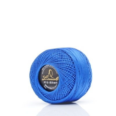 Rolo de linha azul com etiqueta preta e dourada sobre superfície branca