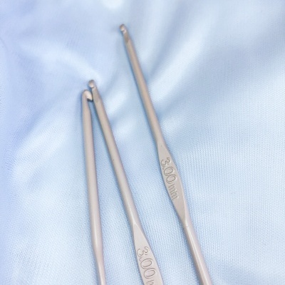 Três agulhas de crochet metálicas com indicação de tamanho 3.00 mm