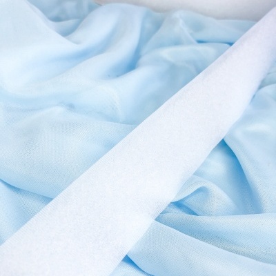 Lenço branco sobre tecido azul claro enrugado