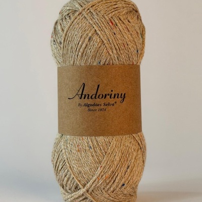 Novelo de fio de algodão bege com pontos coloridos e etiqueta marrom