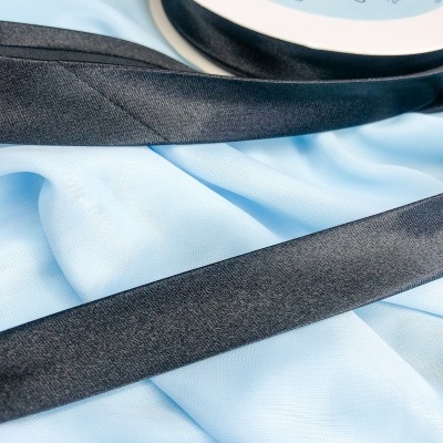 Fita preta em rolo com tecido azul claro por baixo