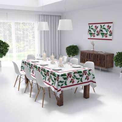 Mesa de jantar com toalha branca com folhas verdes e bagas vermelhas, cadeiras brancas e decoração minimalista.
