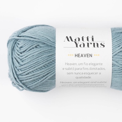 Novelo de fio azul claro com etiqueta branca da marca Matti Yarns, modelo HEAVEN